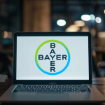 Ein Laptop steht auf einem Tisch, auf dem Bildschirm ist deutlich das Logo von Bayer zu sehen.