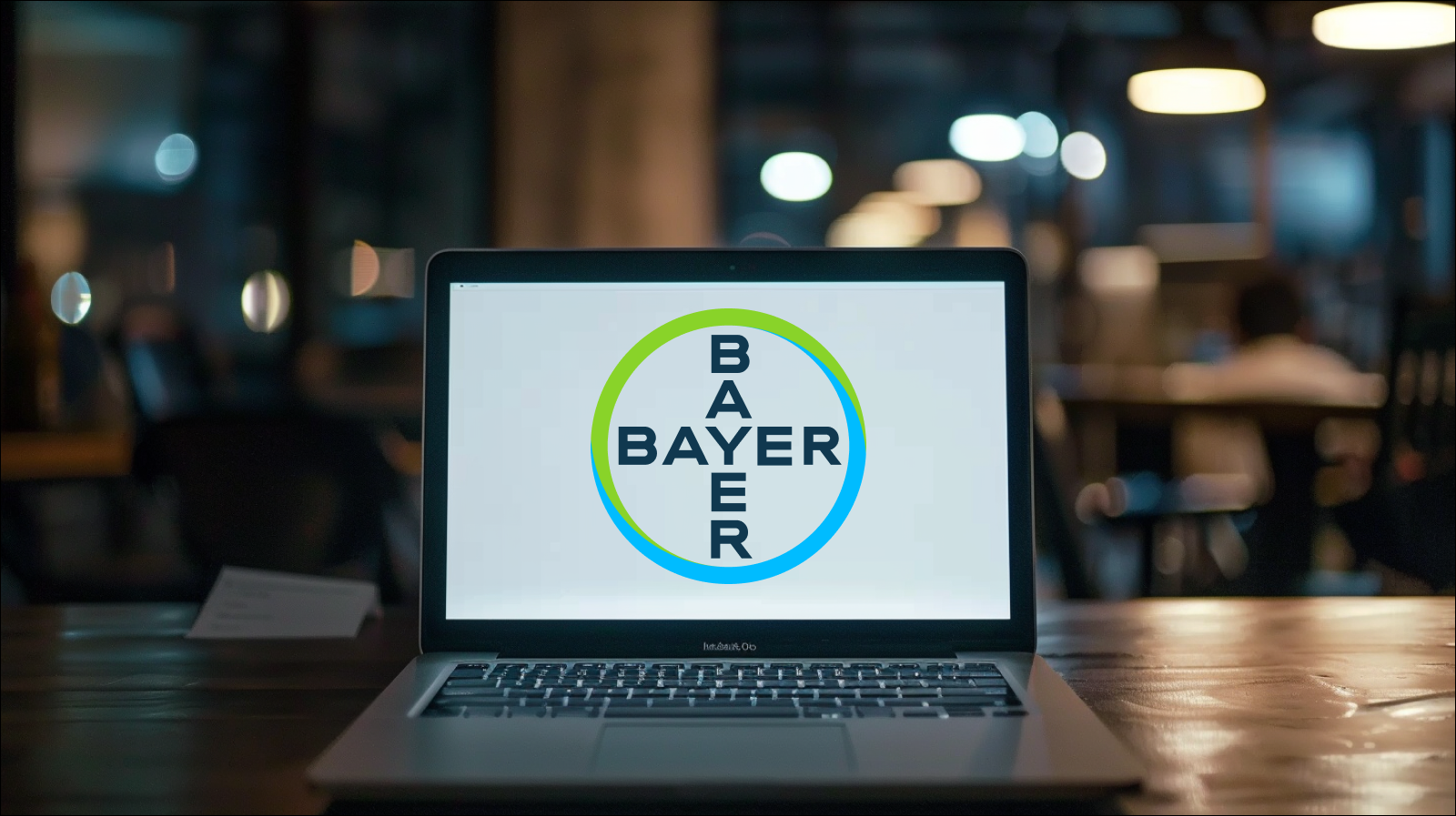 Ein Laptop steht auf einem Tisch, auf dem Bildschirm ist deutlich das Logo von Bayer zu sehen.