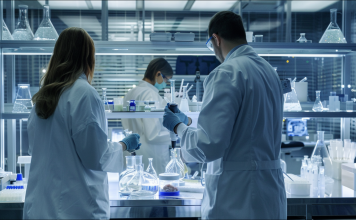 Forscher in weißen Labormänteln arbeiten konzentriert an Experimenten in einem modernen Labor.