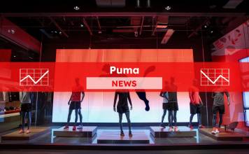 eine Sportbekleidungs-Auslage mit mehreren Schaufensterpuppen, die vor einem großen Puma-Logo aufgestellt sind, mit einem Puma NEWS Banner