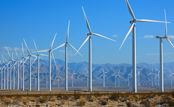 ein Windpark mit zahlreichen großen Windturbinen, verteilt über eine Wüstenlandschaft