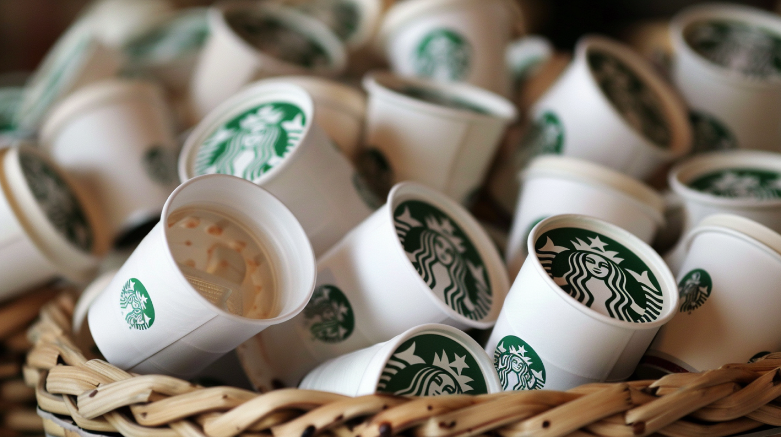ein Stapel Starbucks-Kaffeetassen, gestapelt in einem geflochtenen Korb