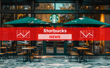 Der Eingang eines Starbucks-Cafés mit Glastüren und Sitzgelegenheiten im Freien unter Sonnenschirmen, mit einem roten NEWS Banner