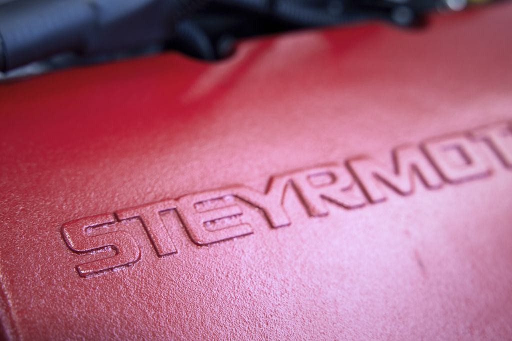 Nahaufnahme von roter Motorblock-Abdeckung mit dem Steyr Motors-Schriftzug