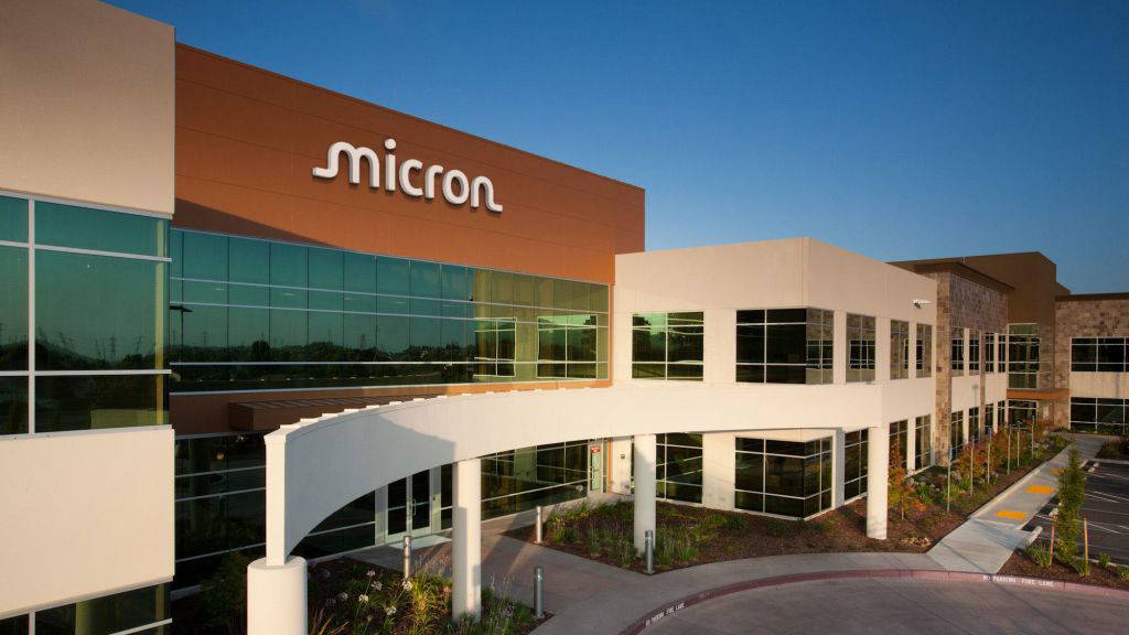 Moderne Firmenzentrale von Micron Technology in Folsom, Kalifornien, mit Glasfassade und geschwungener Eingangspassage bei Sonnenuntergang.