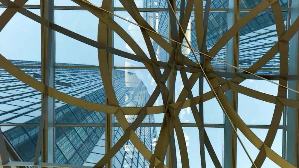 Blick durch ein künstlerisch gestaltetes Deckenelement auf die Glasfassade des Deutsche-Bank-Hochhauses in Frankfurt/Main – modernes Design und Transparenz.
