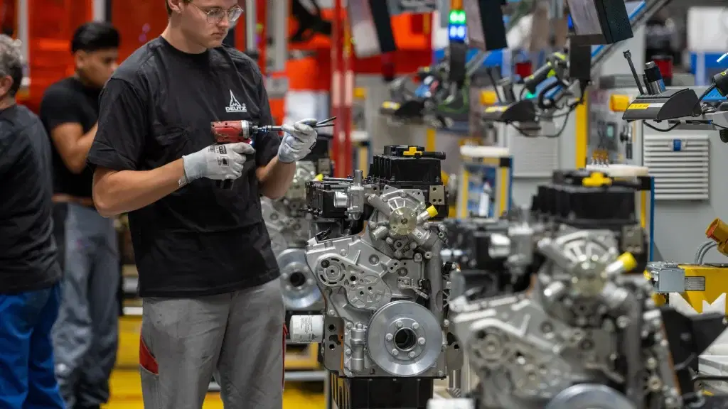 Mitarbeiter der Deutz AG bei der Montage eines Motors auf der Fertigungslinie in Köln, moderner Industriearbeitsplatz im Fokus