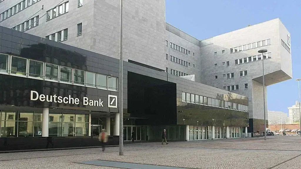 Außenansicht eines modernen Deutsche-Bank-Gebäudes in Mailand mit dunkler Glasfassade und großzügigem Vorplatz.