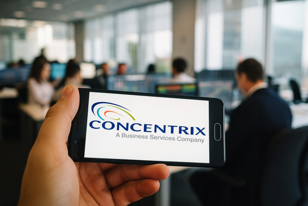 Eine Hand hält ein Smartphone mit dem Concentrix-Logo auf dem Display, im Hintergrund ein modernes Großraumbüro mit arbeitenden Personen und Monitoren.
