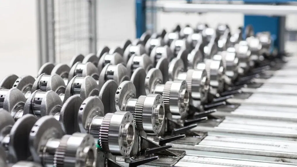 Reihe von Kurbelwellen in der Fertigungshalle der Deutz AG, hochpräzise Bauteile auf Transportvorrichtungen