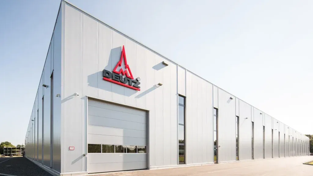 Außenansicht einer modernen Produktionshalle der Deutz AG mit Firmenlogo an der Fassade, Tageslichtaufnahme bei klarem Himmel