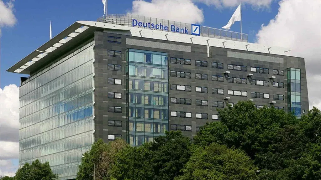 Deutsche Bank-Aktie: Zentralbank-Woche entscheidet über die Richtung! Bürogebäude der Deutschen Bank in Warschau mit moderner Glas-Stahl-Architektur und prominentem Logo – internationales Standortnetz.